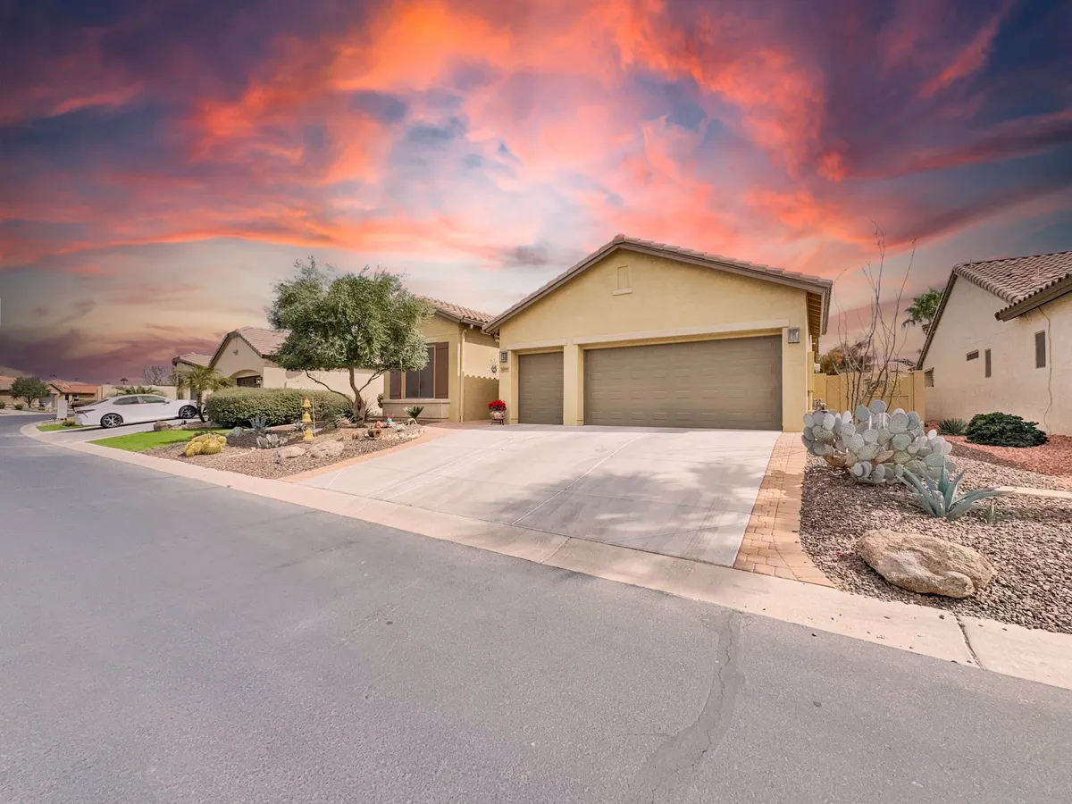 A welcoming exterior view of the home at sunset, featuring manicured landscaping, a broad driveway, and a cozy porch. The tranquil skies and soft lighting evoke a sense of relaxation and provide a glimpse of outdoor gathering areas.